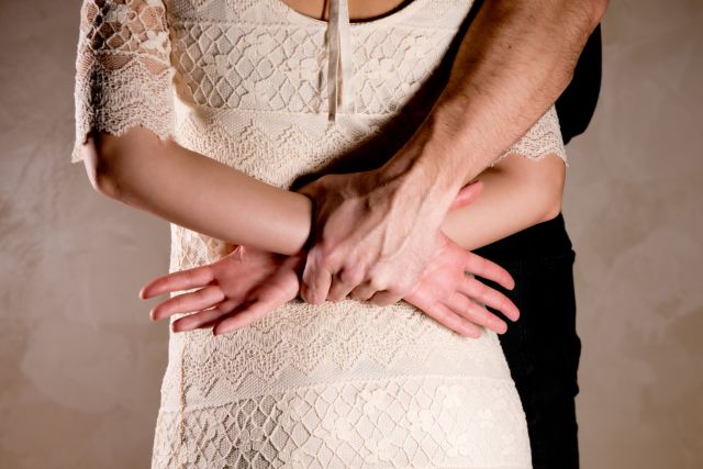 女性をつかむ男性